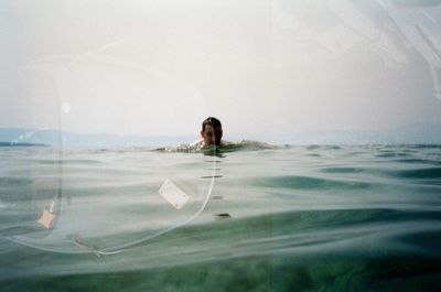 Digital composite image of man swimming in pool