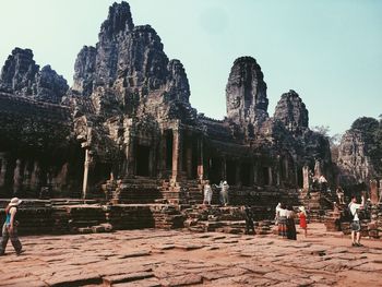 People at historic temple against sky