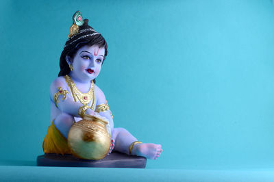 Man looking away while sitting against blue background