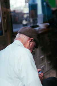 Side view of man looking at camera