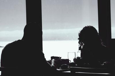 Silhouette couple having lunch at table in restaurant