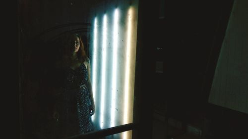 Woman standing by window at home