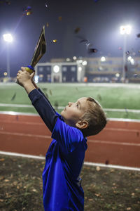 Cute boy holding trophy