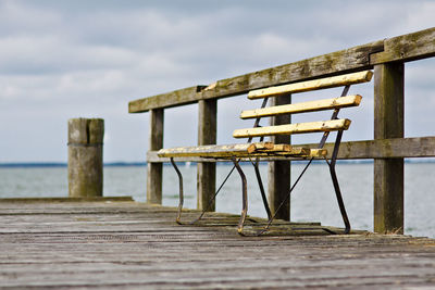 Empty bench against calm lake