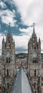 Historic cathedral in city against cloudy sky