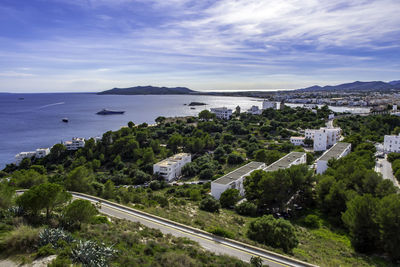 High angle view of city by sea against sky
