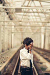 Young man standing on railroad track