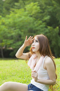 Woman sitting on field at park