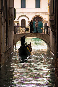 Arch bridge over canal amidst buildings