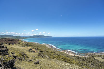 Scenic view of beach against blue sky