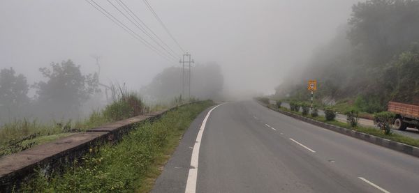 Road amidst trees against sky