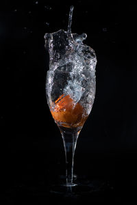 Close-up of water splashing in glass against black background