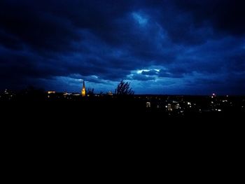Silhouette city against sky at night