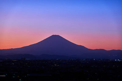 Scenic view of silhouette mountains against romantic sky at sunset