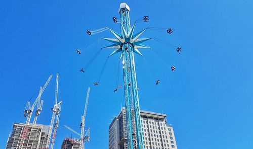 Low angle view of ferris wheel against blue sky