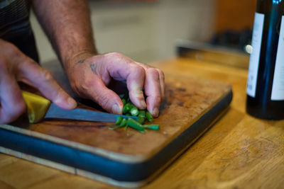 Midsection of man preparing food on cutting board