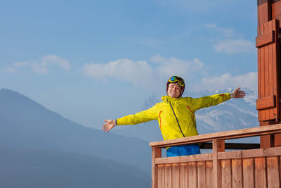 Low angle view of woman standing on mountain against sky