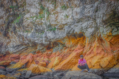 Man crouching on rock