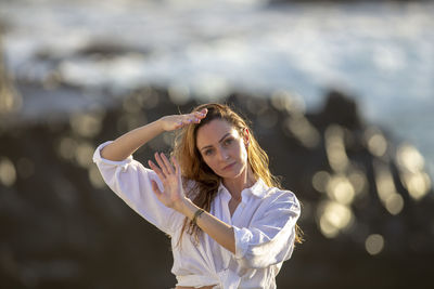 Portrait of young woman looking away while standing outdoors