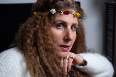 Portrait of woman wearing flowers indoors