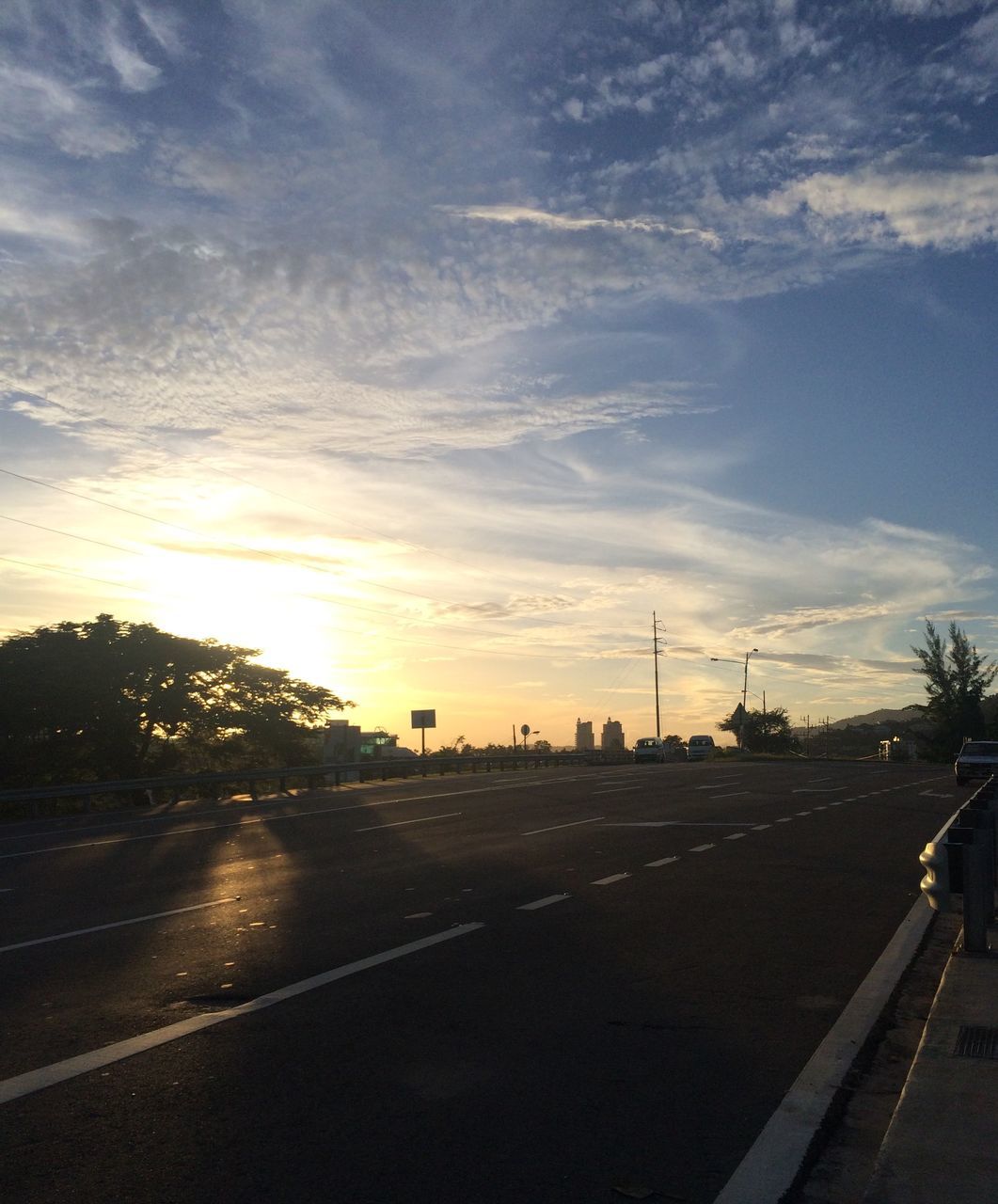 transportation, road, sky, road marking, street, the way forward, car, sunset, cloud - sky, land vehicle, silhouette, tree, mode of transport, diminishing perspective, street light, cloud, outdoors, vanishing point, no people, highway