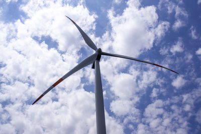 Wind turbine in backlight with cloudy sky