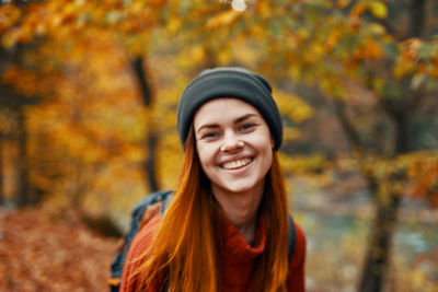 Portrait of smiling young woman during autumn