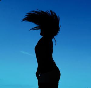 Silhouette woman standing against blue sky