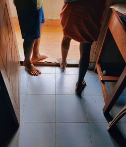 Low section of people standing on tiled floor