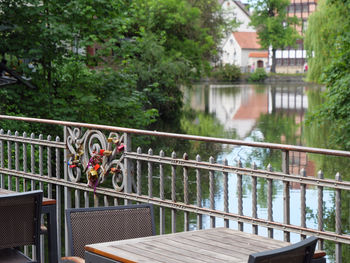 Footbridge over river amidst trees and buildings