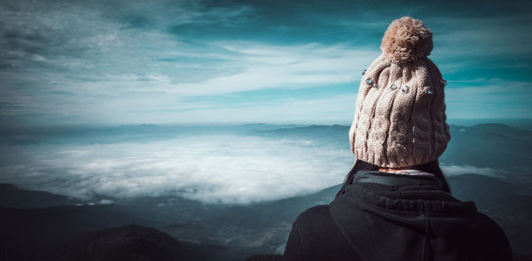 Rear view of woman looking at mountain against sky