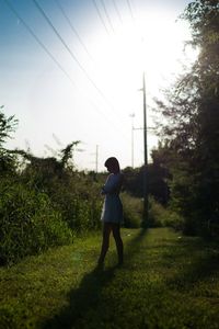 Rear view of woman walking on grass