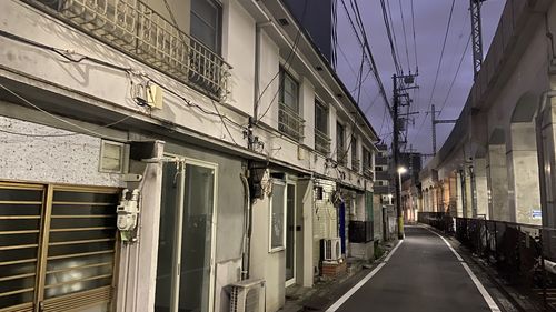 Empty road amidst buildings in city