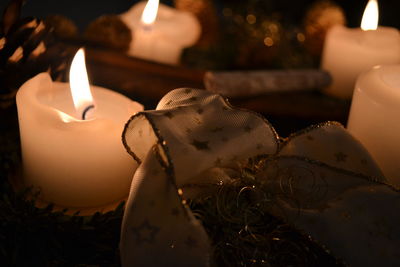 Close-up of illuminated candles and decoration on table