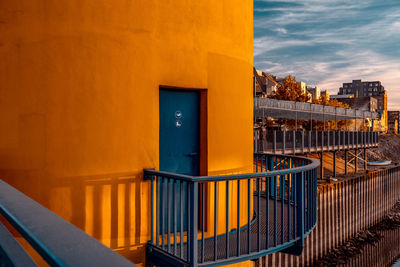 Yellow door by building against sky