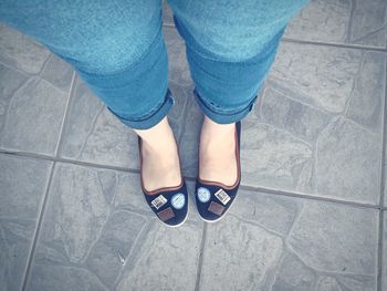 Low section of woman standing on tiled floor