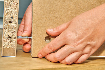 Close-up of hands holding coffee cup on table