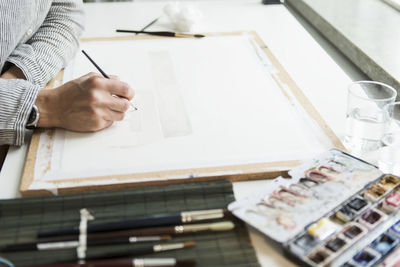 Cropped image of artist painting on canvas at creative office