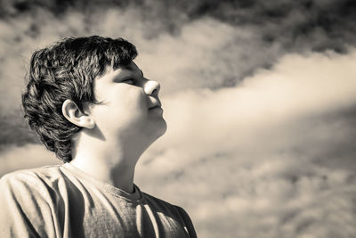 Portrait of boy looking away against sky