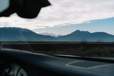 Scenic view of mountain landscape seen through car windshield