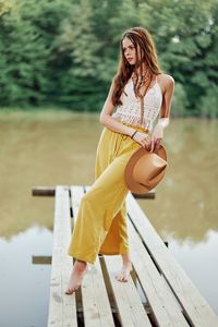 Portrait of young woman sitting on pier