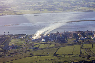 Aerial view of agricultural field in city against sky