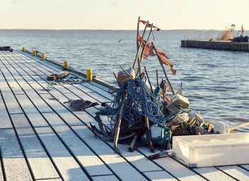 Frozen pier with fishing accessories - red flags, anchors, ropes and seagull