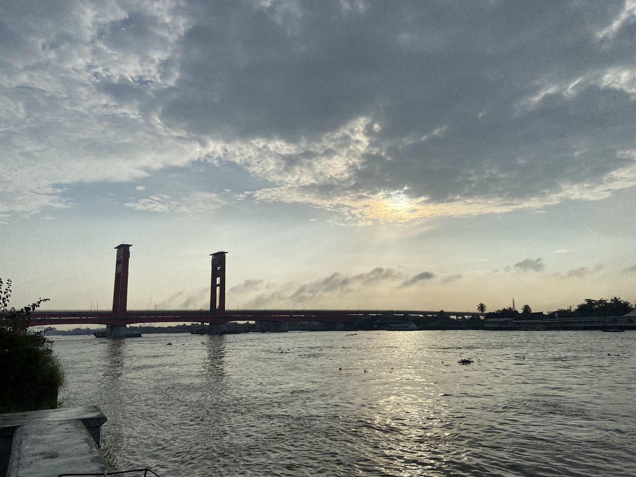 BRIDGE OVER RIVER AGAINST SKY DURING SUNSET