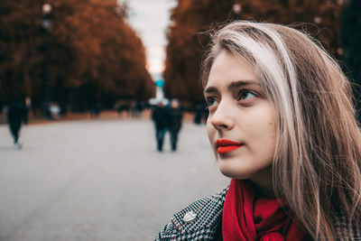 Close-up of young woman looking away while standing outdoors