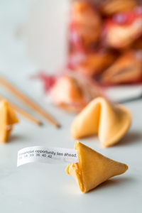 Fortune cookies with a fortune note sticking out of the one in front.