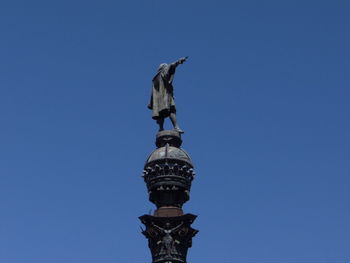 Low angle view of statue against clear blue sky