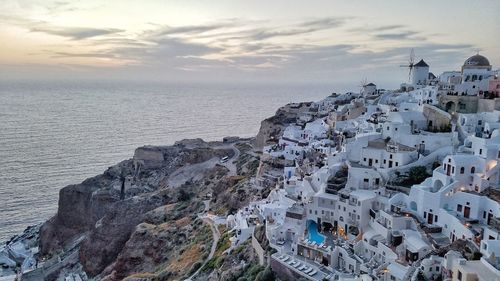 High angle view of town by sea against sky