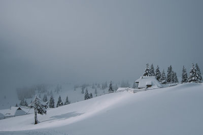 Snow covered landscape against clear sky