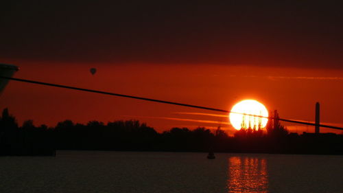 Scenic view of lake against orange sky during sunset